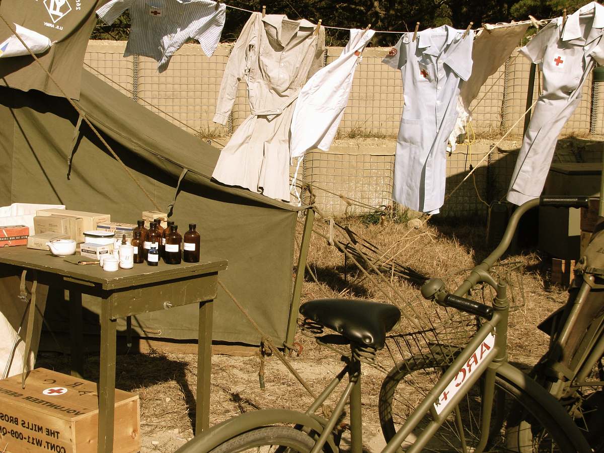 wheel four white dresses hang beside brown table bicycle
