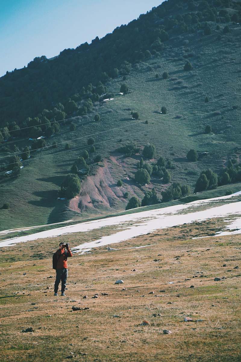 kyrgyzstan man wearing orange shirt hiking landscape