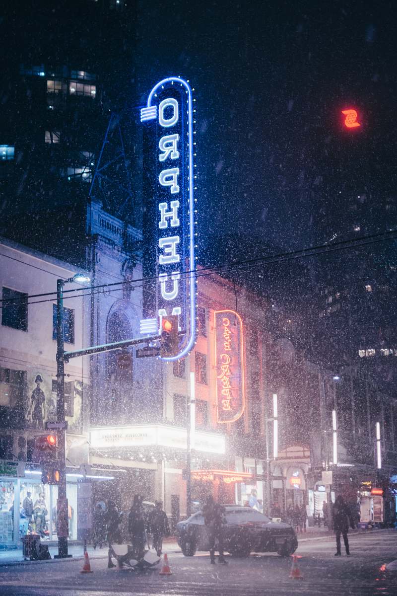 outdoors people walking near lighted buildings at nighttime snow