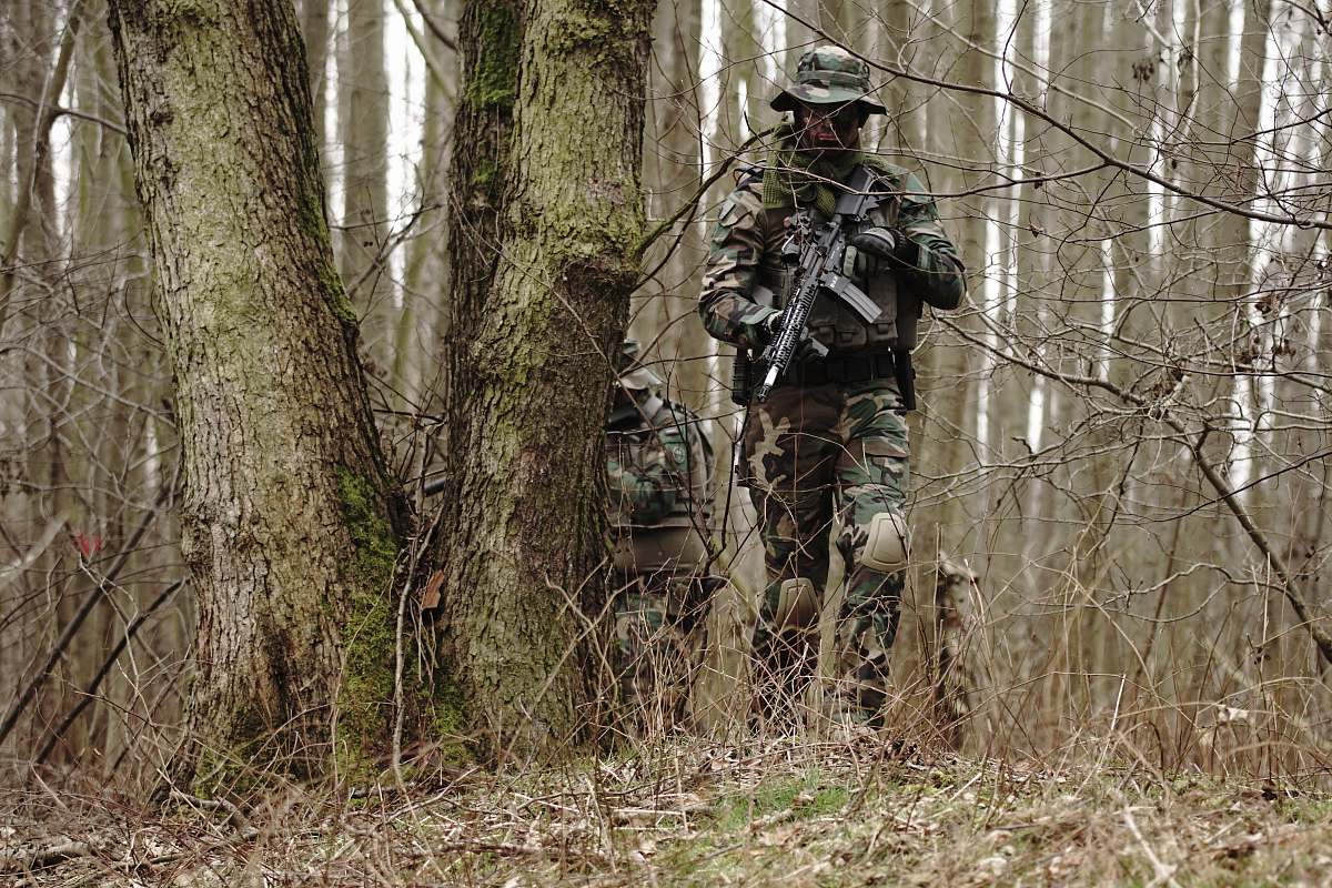 human man holding rifle near the tre military