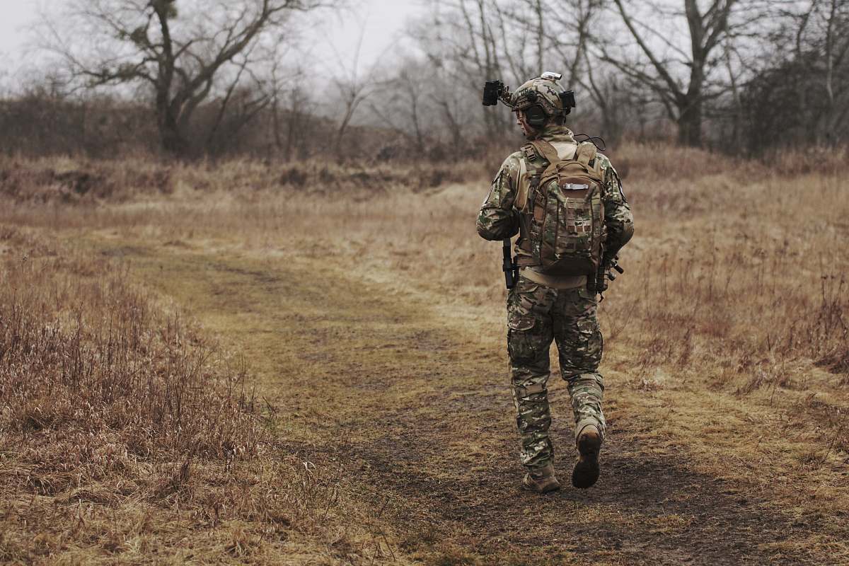 human man walking on brown grass field military
