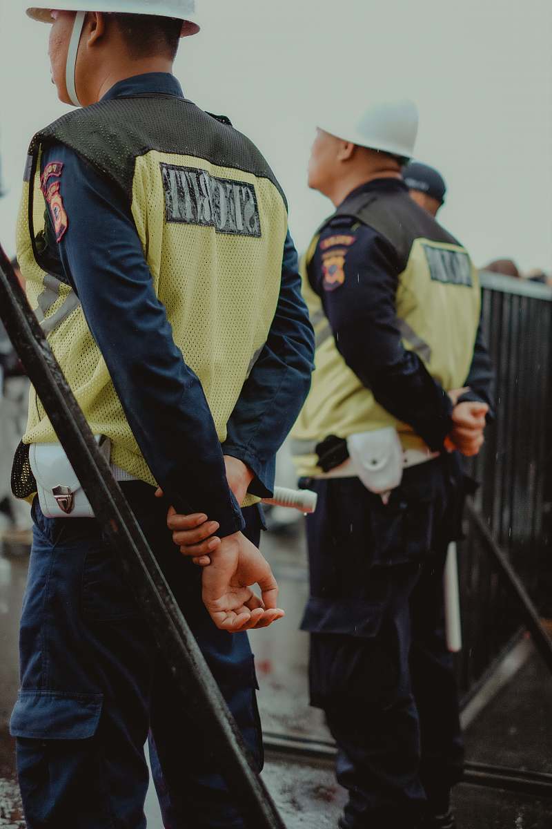 people policeman standing near black steel fence human