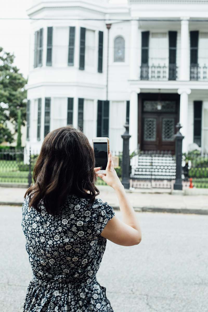human woman taking photo of house phone