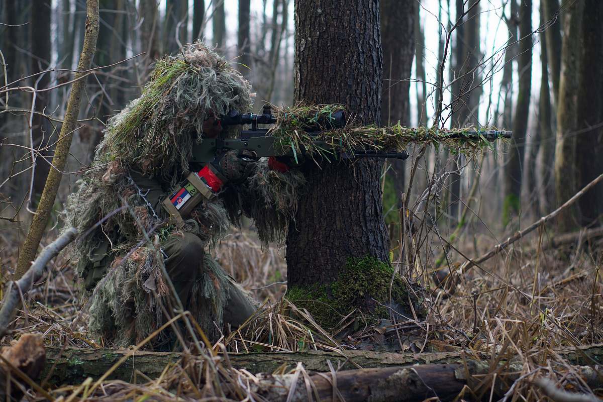 tree person holding green rifle shooting sniper
