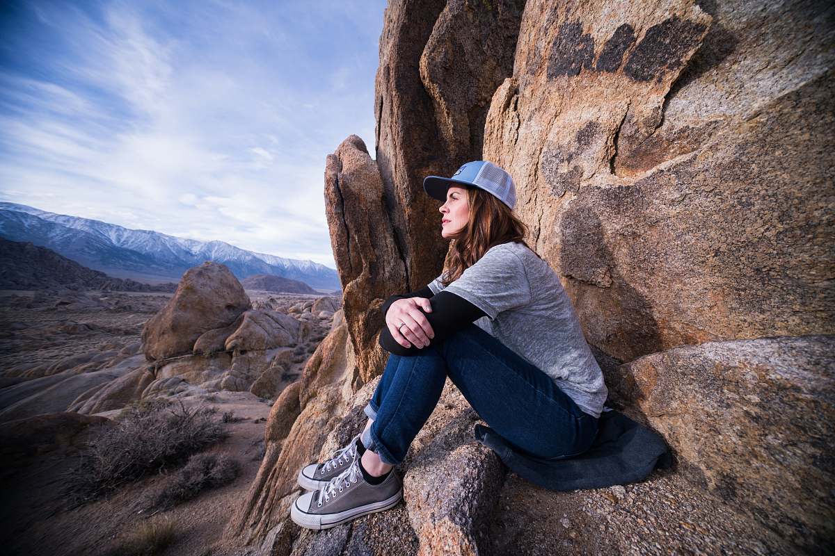 clothing woman sitting on brown rock formation footwear