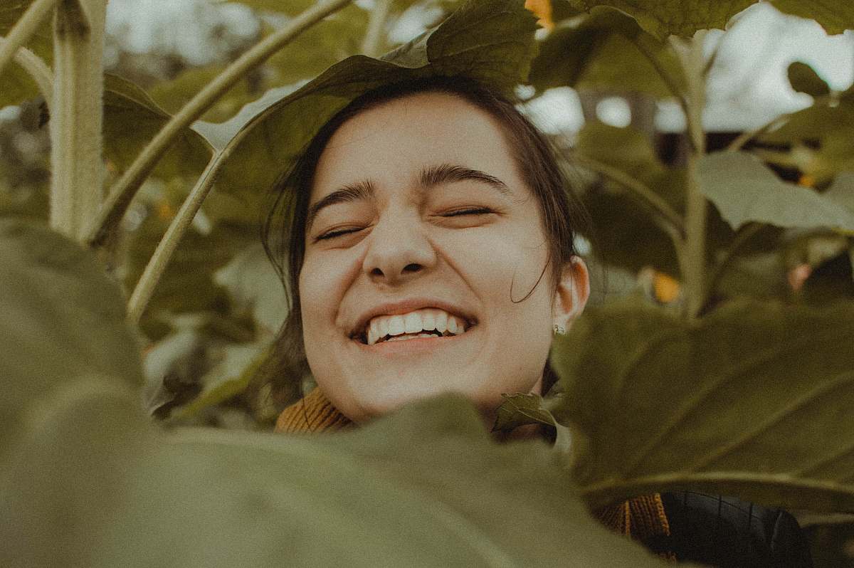 person woman smiling between plants people