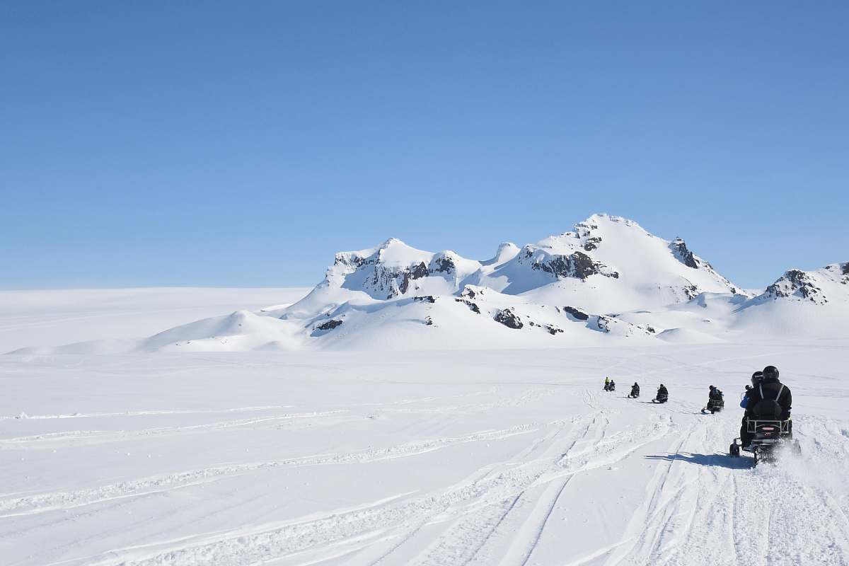 Experience the thrill of adventure in this stunning image capturing a group of people riding snowmobiles across a breathtaking snowy glacier landscape. The scene encapsulates the excitement of outdoor exploration and the beauty of nature, making it perfect for travel blogs, adventure sports promotions, and winter tourism campaigns. Ideal for showcasing winter activities, this image highlights the joy of exploration in a pristine, icy environment.