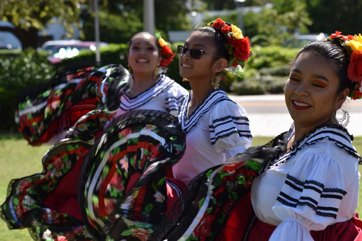 human three women wearing dress on grass field festival
