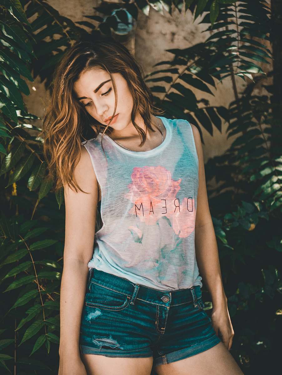 human woman posing for photo beside green plants people