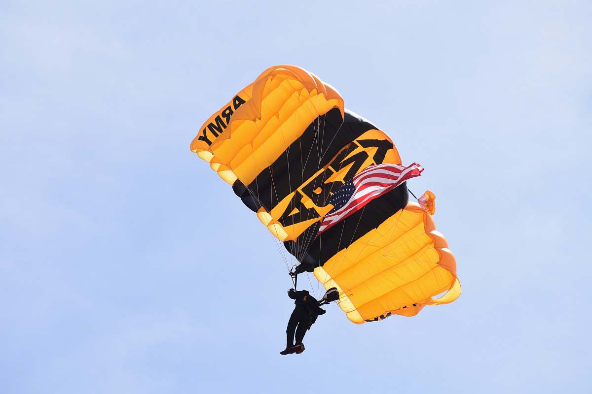  photo of man with yellow Army parachute 