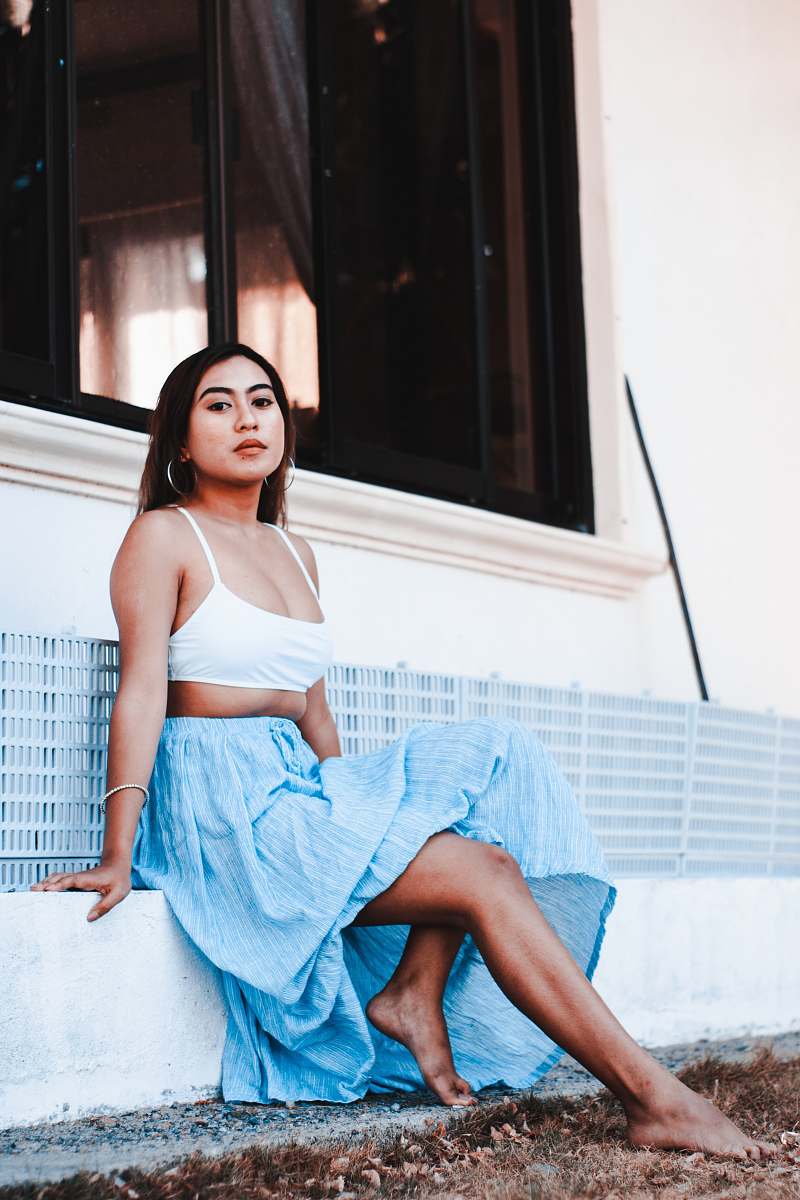 clothing barefooted woman sitting near white wall robe