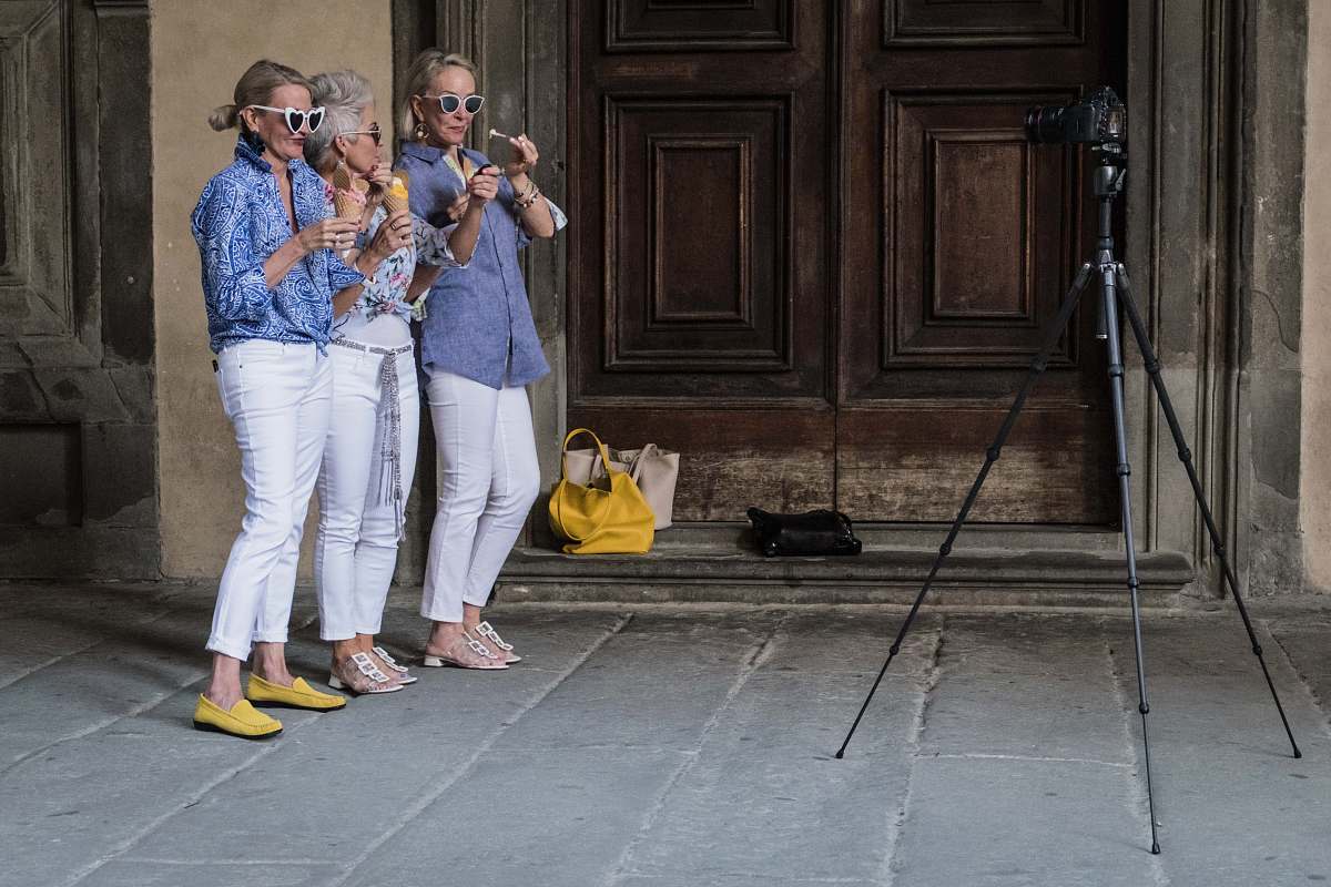 clothing three women standing while holding ice cream beside building footwear