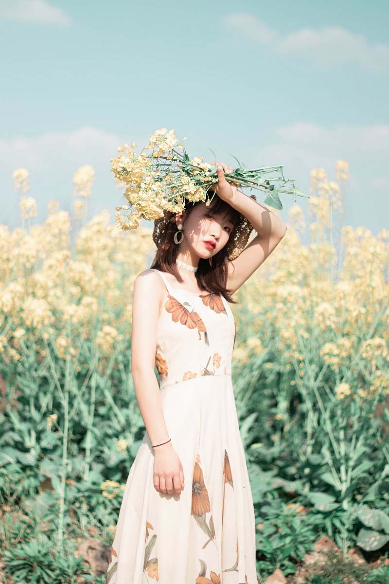 clothing woman holding yellow-petaled flowers above her head gown