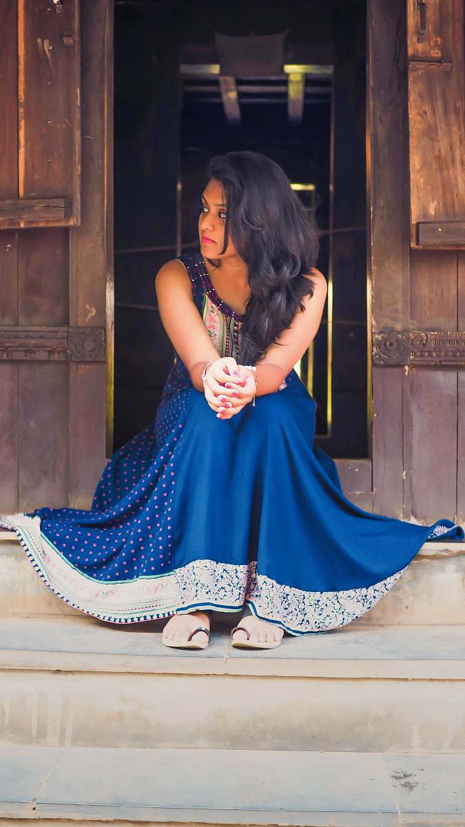 clothing woman in blue and white polka-dot sleeveless dress sitting on stairs evening dress