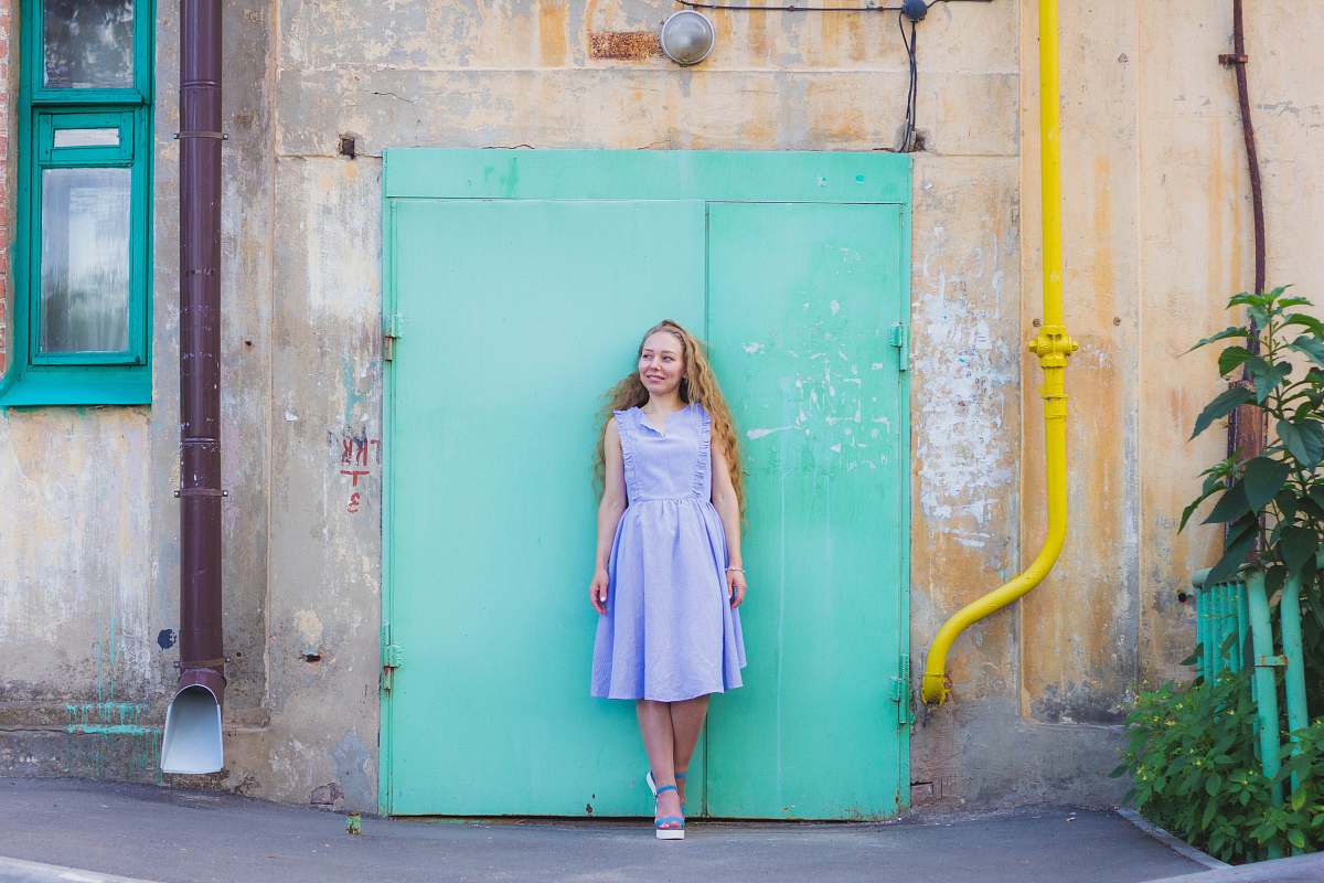 clothing woman standing against teal door evening dress