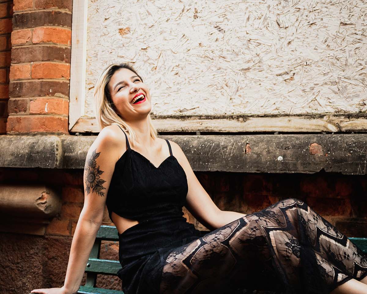 clothing woman wearing black spaghetti-strap dress sitting on ground evening dress