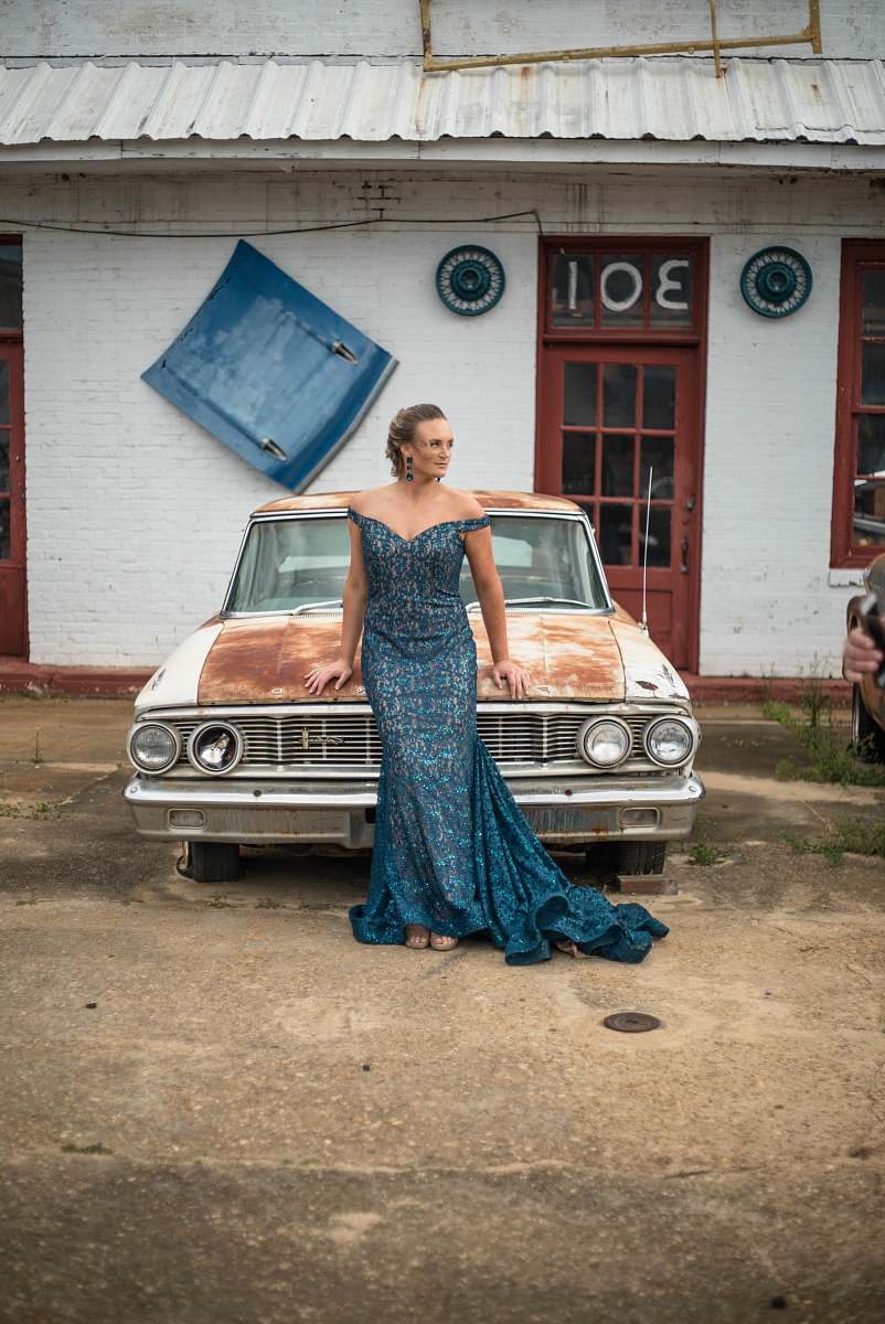 clothing woman wearing blue off-shoulder dress standing in front of white classic vehicle evening dress