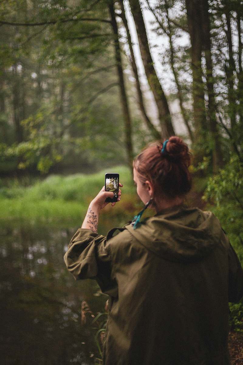 clothing woman wearing jacket taking photo of trees human