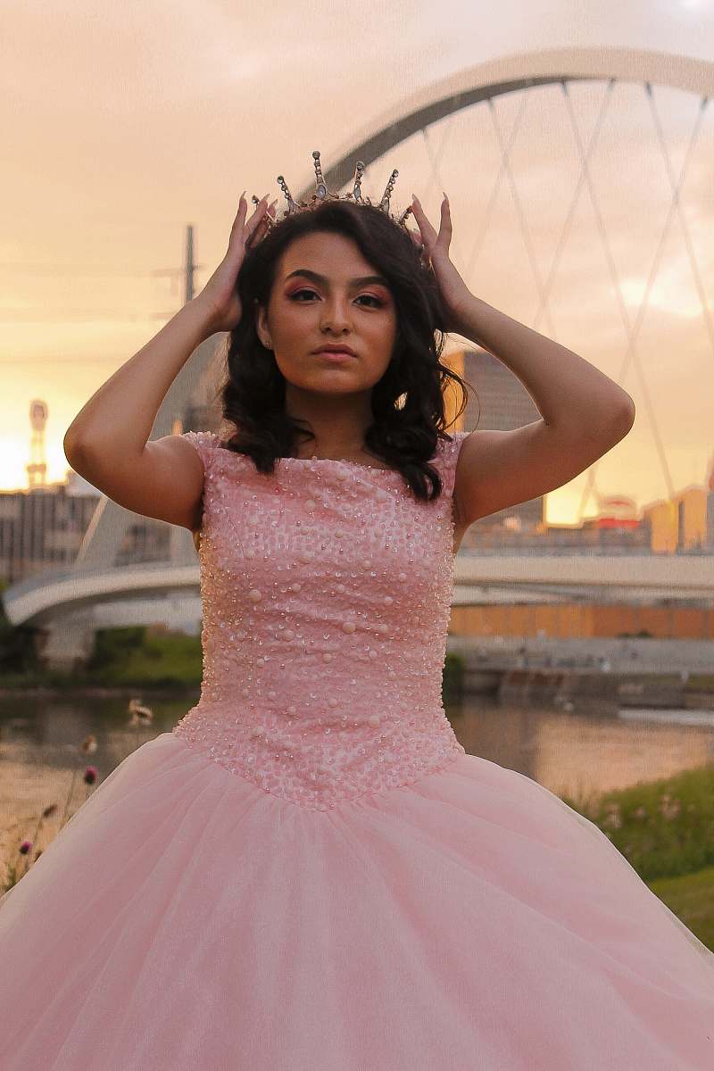 clothing woman wearing pink sleeveless dress standing and touching her crown evening dress