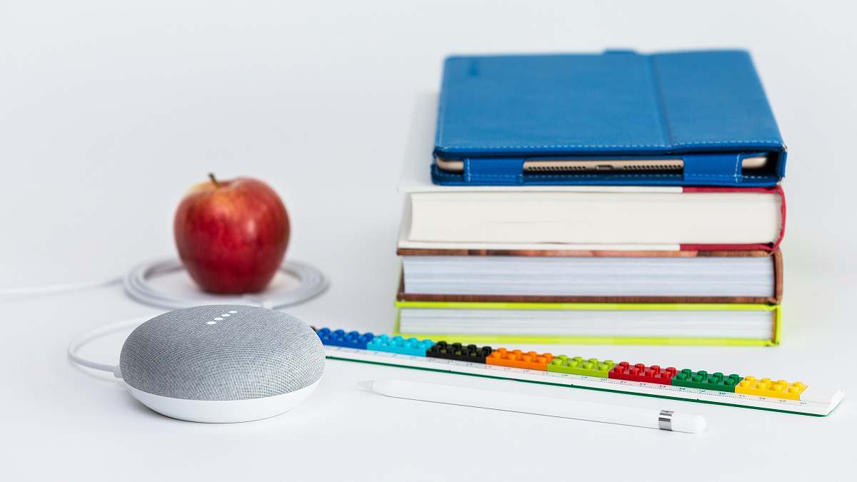 food honeycrisp apple fruit near books and chalk Google Home Mini smart speaker fruit