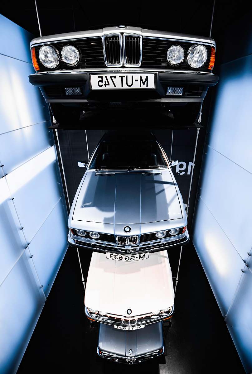 car several BMW vehicles suspended on air inside showroom transportation