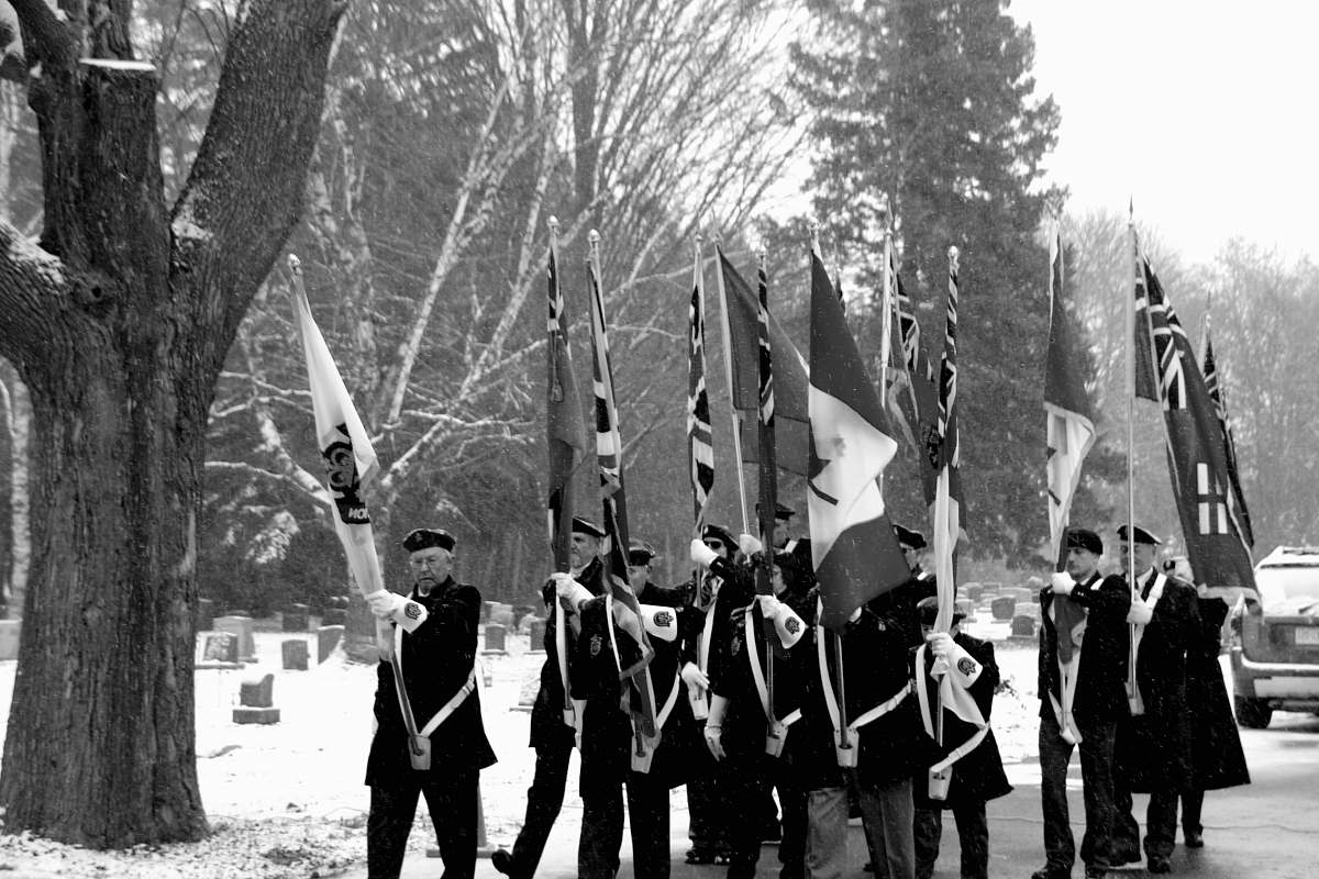 human grayscale photo of people marching while holding flags person