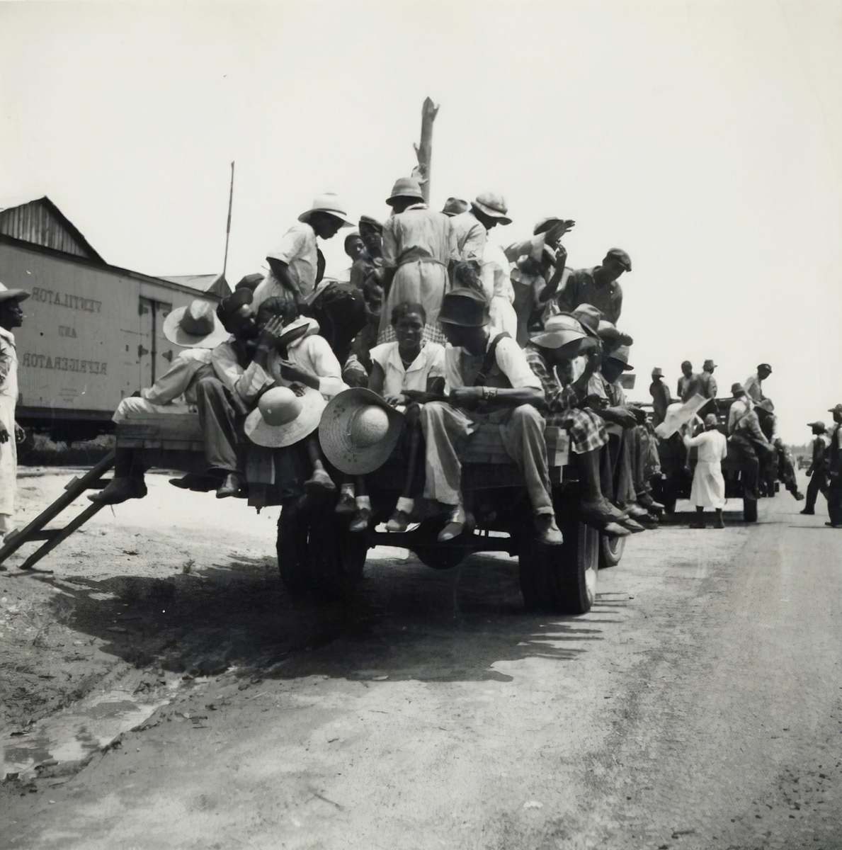 machine grayscale photography of people riding truck wheel