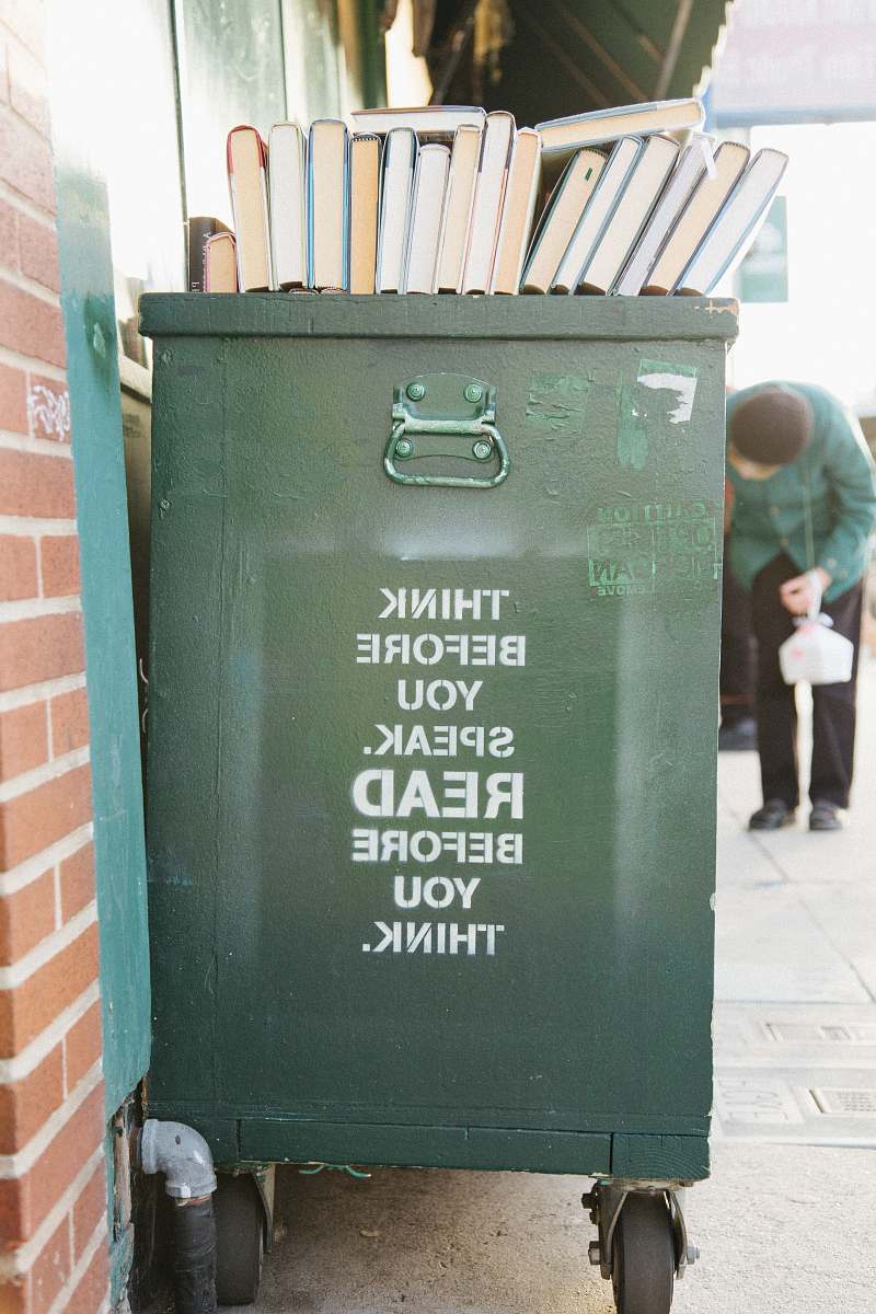 human books over green trolley bin quote