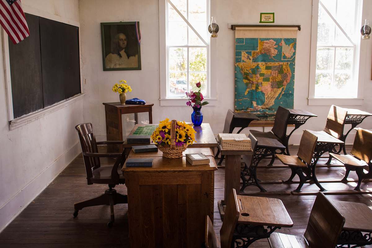 furniture vacant white painted classroom with chairs, tables , and map on the wall room