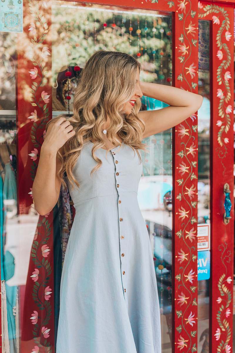 fashion woman in blue tank dress leaning on glass wall apparel