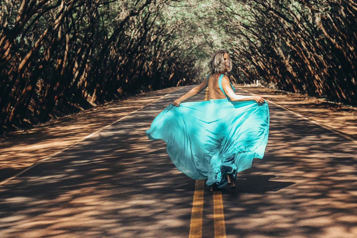 apparel woman wearing teal backless dress walking on asphalt road robe