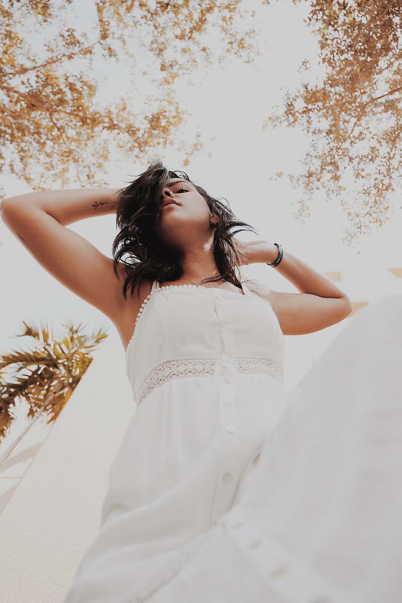 apparel woman wearing white tank dress while holding her head evening dress