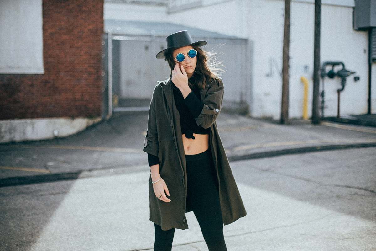 person woman standing behind white and brown concrete wall people