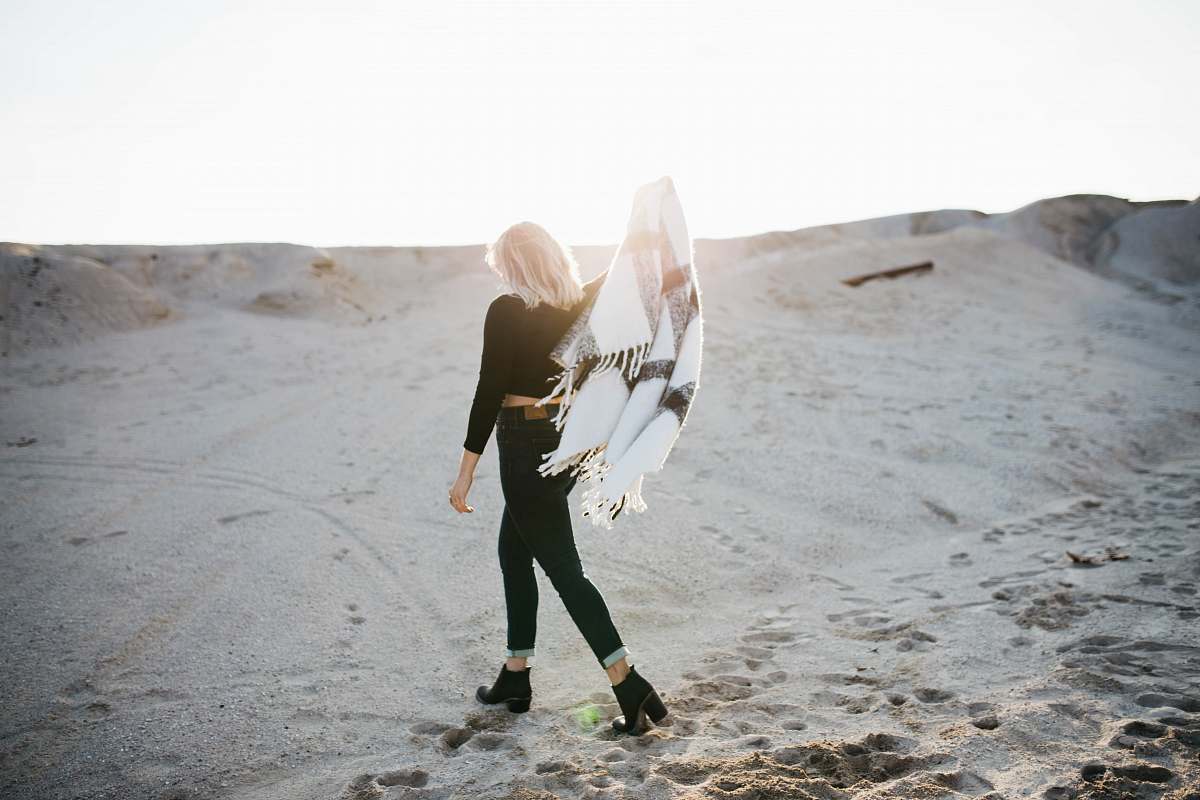 people woman standing on gray sand under sunrise woman