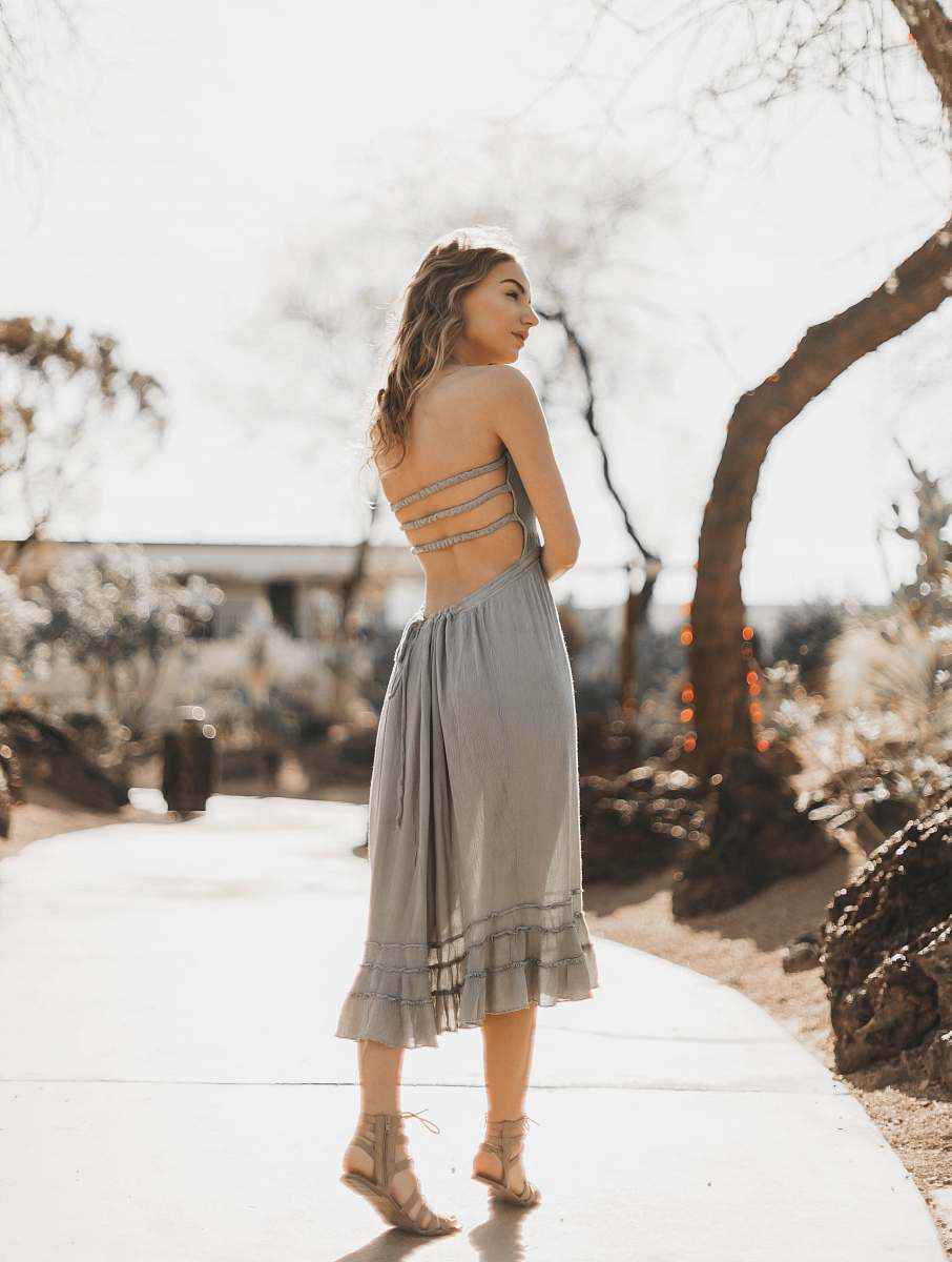 apparel woman wearing gray halter dress standing on pathway clothing