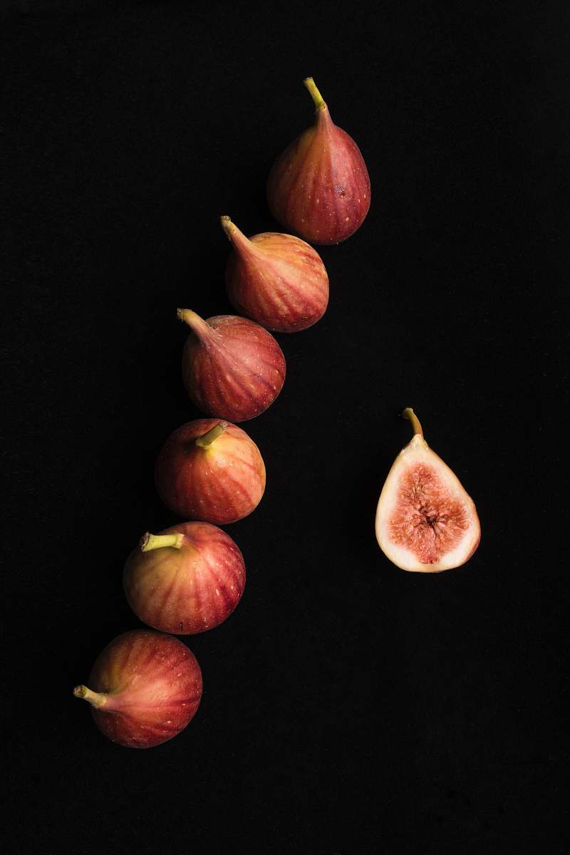fruit six onions on black surface fig