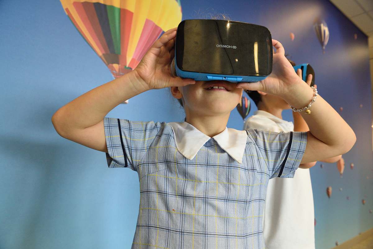 person boys using blue and black virtual reality headset primary school