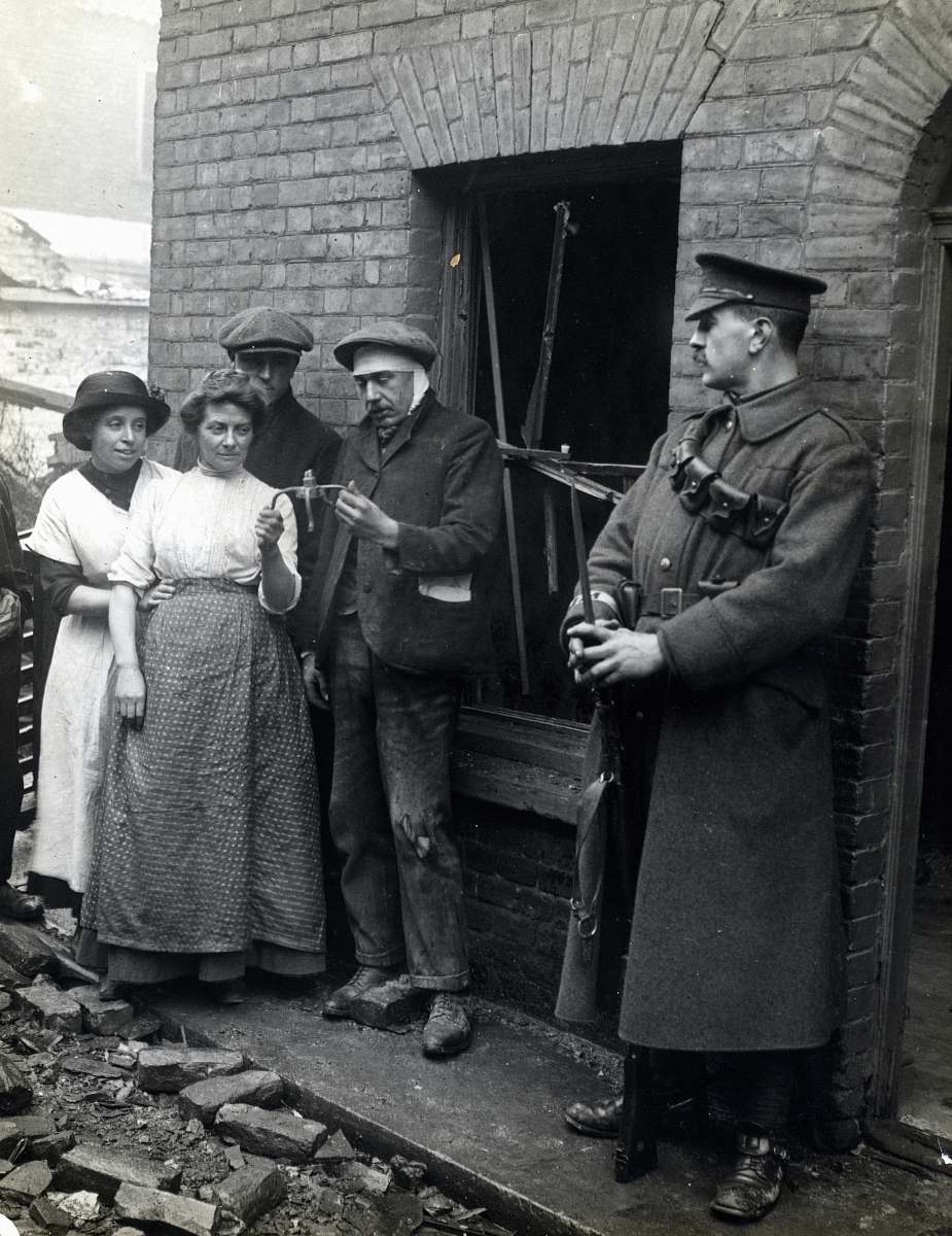 person grayscale photography of people standing near house clothing