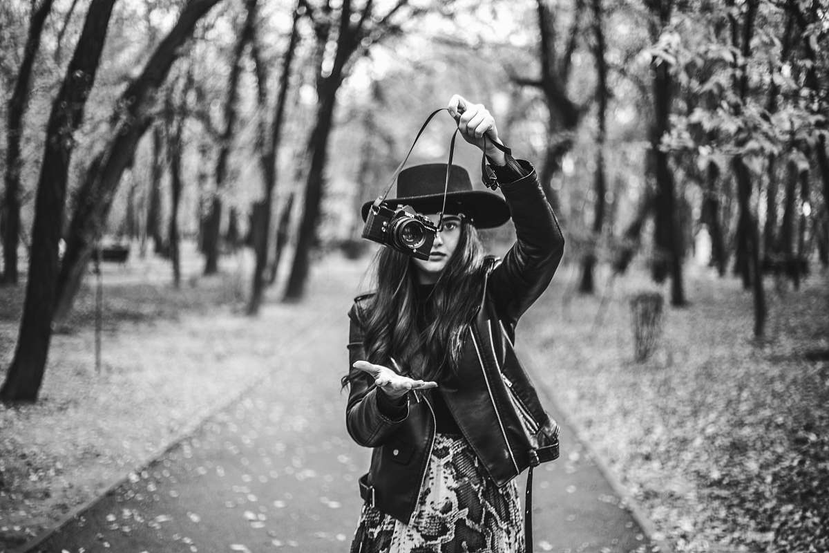 person grayscale photography of woman holding camera black-and-white