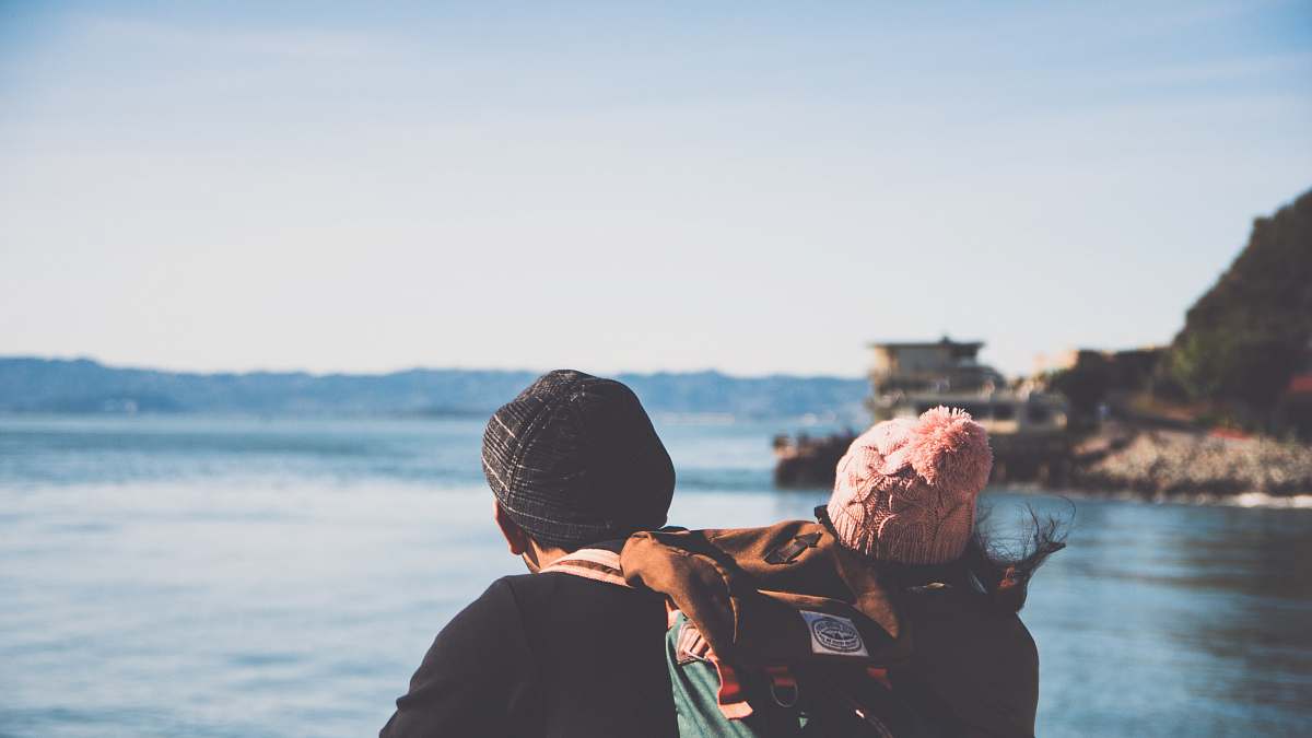 apparel man and woman facing body of water clothing