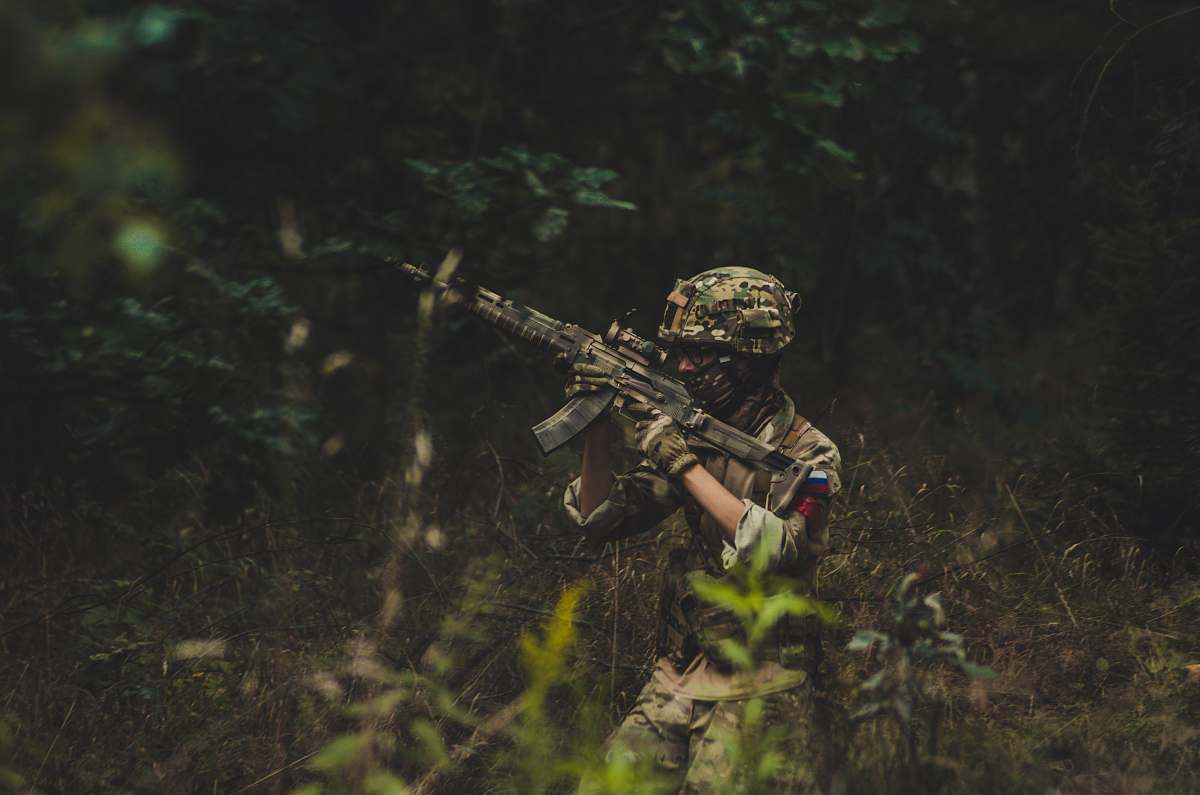 military man pointing assault rifle near trees sniper