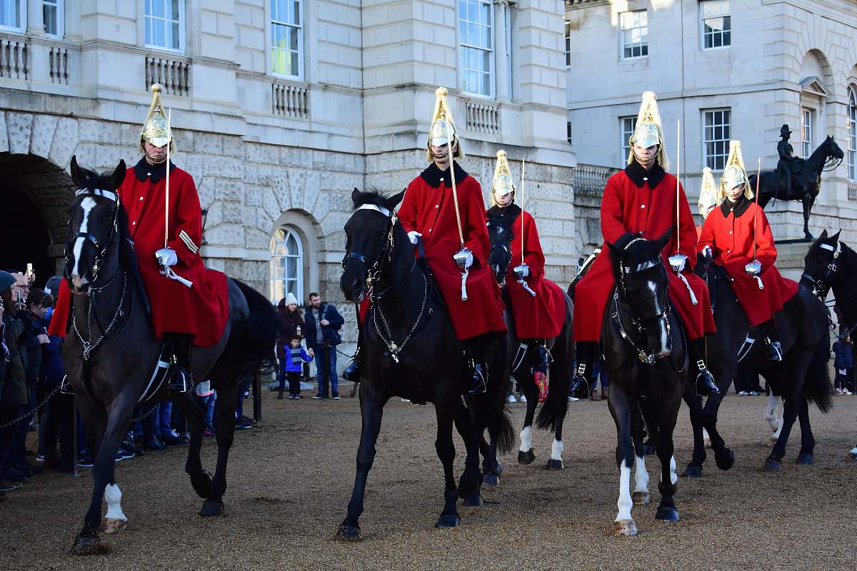 person man wearing red coat riding horses during daytime horse