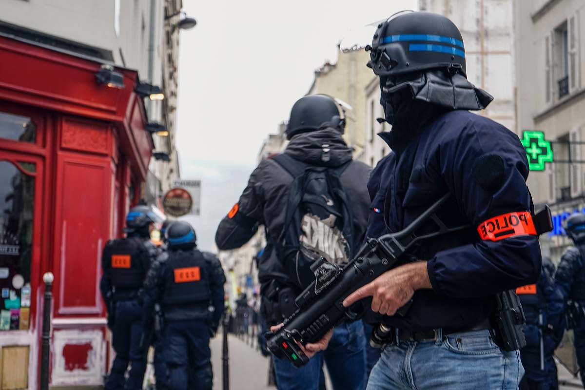 person Police wearing black helmets and holding guns apparel