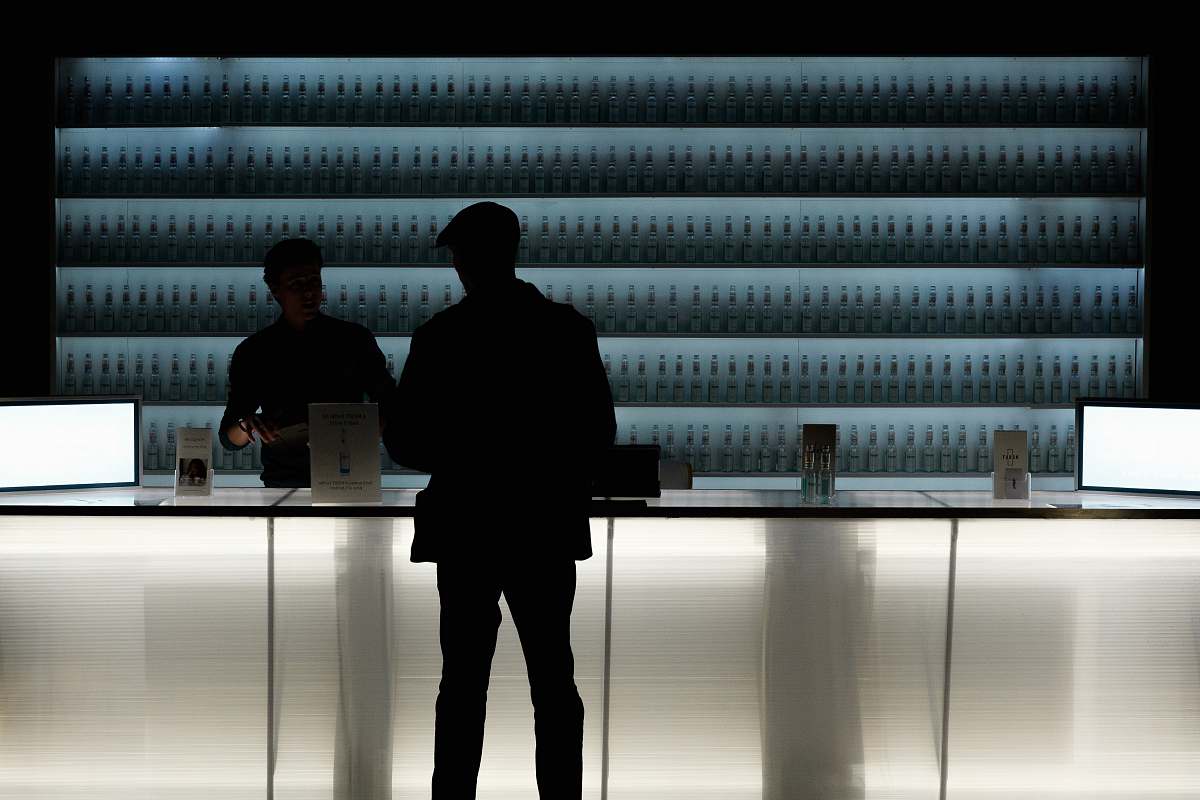 person silhouette of man standing near glass counter top furniture