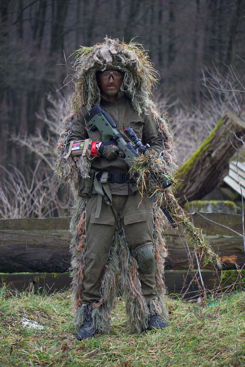 sniper soldier covered with grass holding sniper rifle military