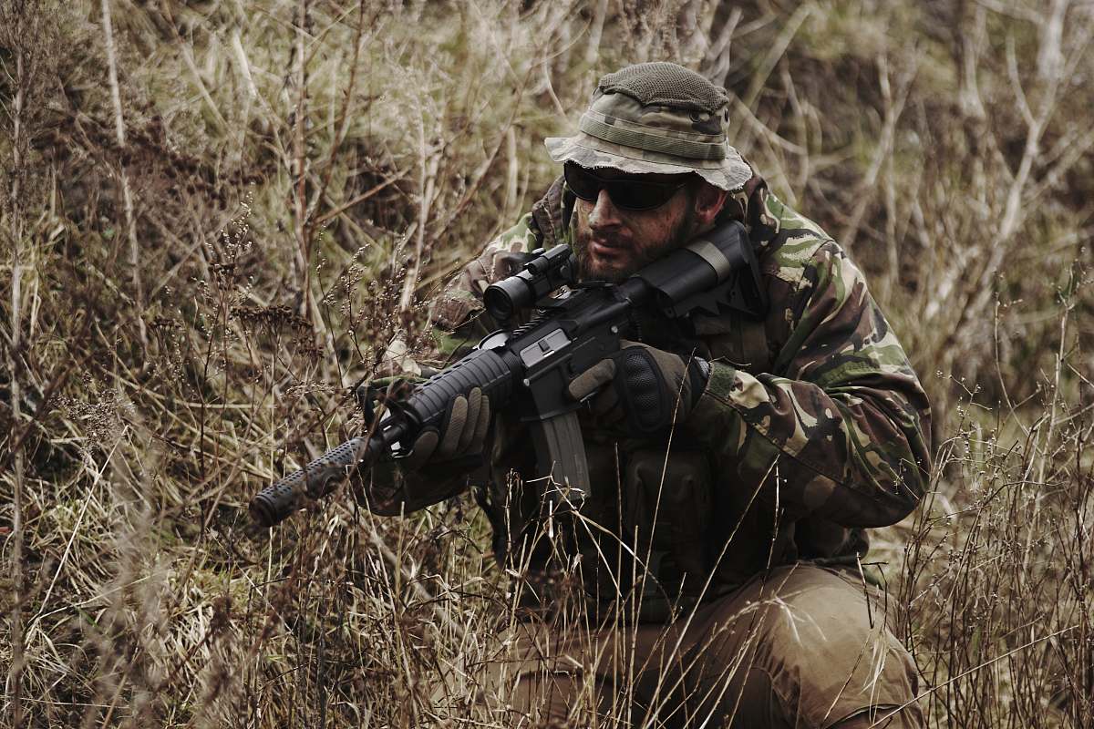 person soldier holding black assault rifle people