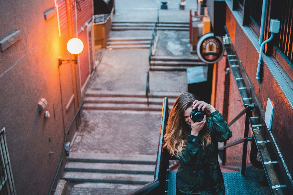 person woman taking a picture on stairs photo