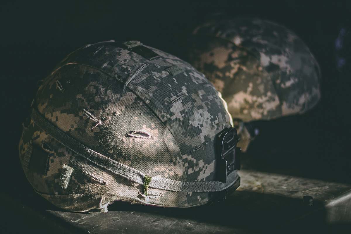 hat gray and brown camouflage nutshell helmet on table grey