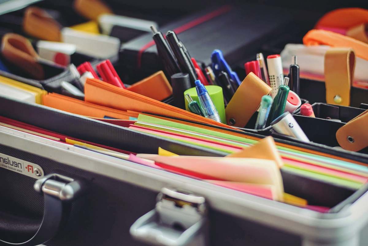 work assorted pen and colored papers in organizer case stationery