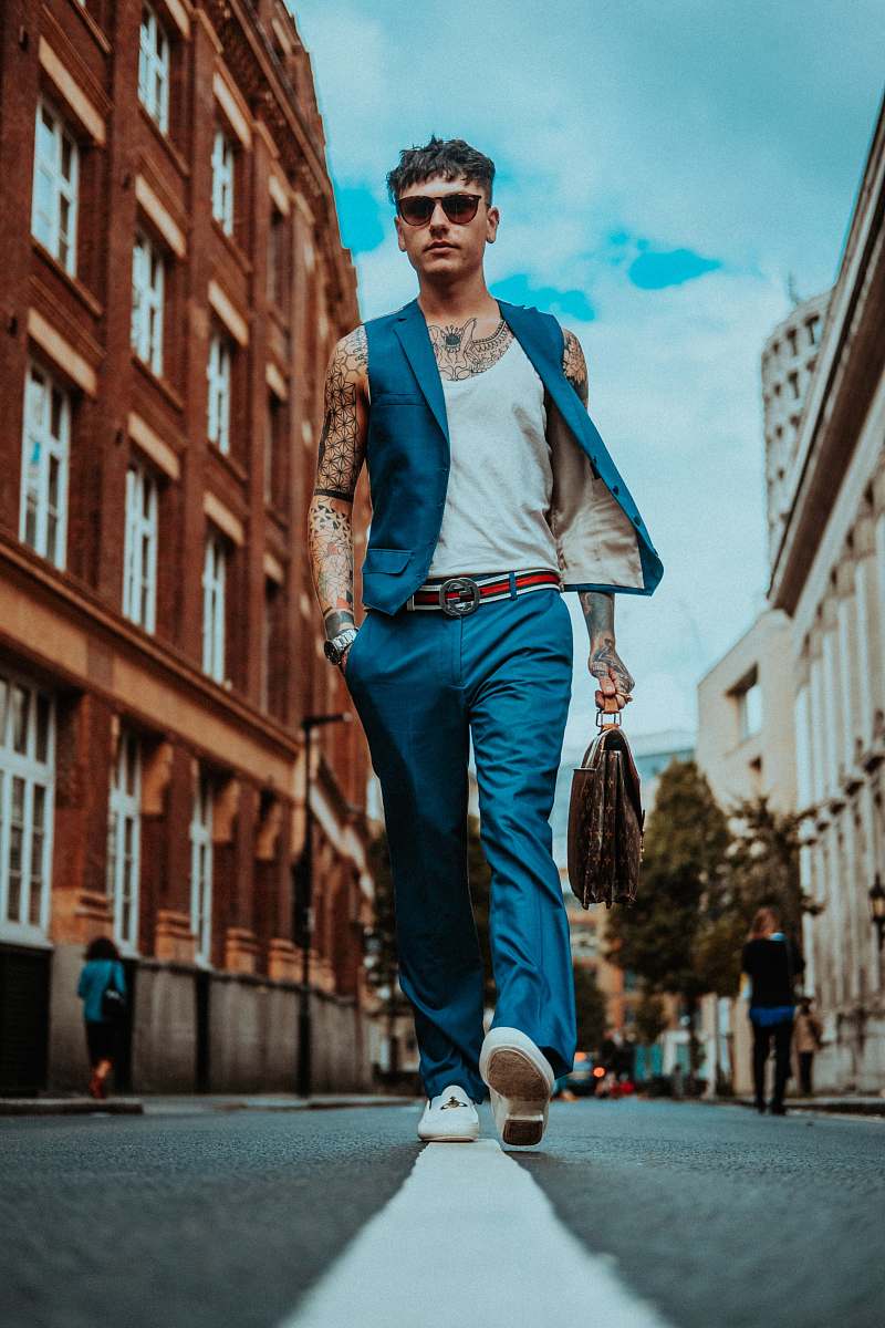 human man walking in the middle of the road during daytime person
